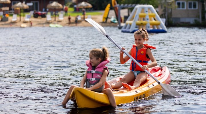 Two little girls kayaking on an outfitter's lake