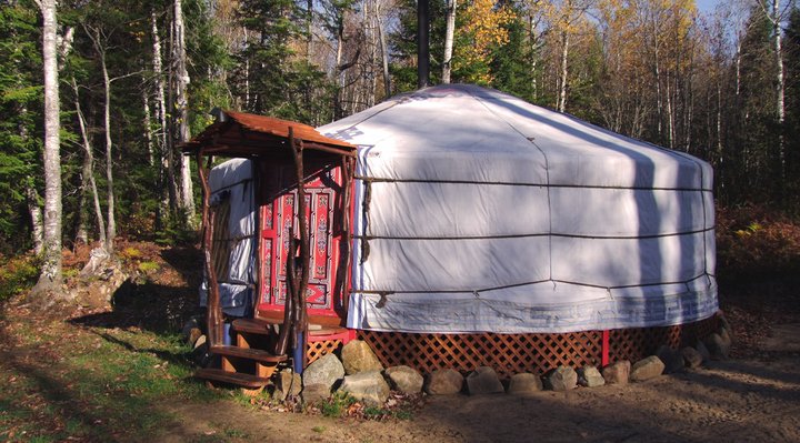 A white and red yurt at an outfitter.