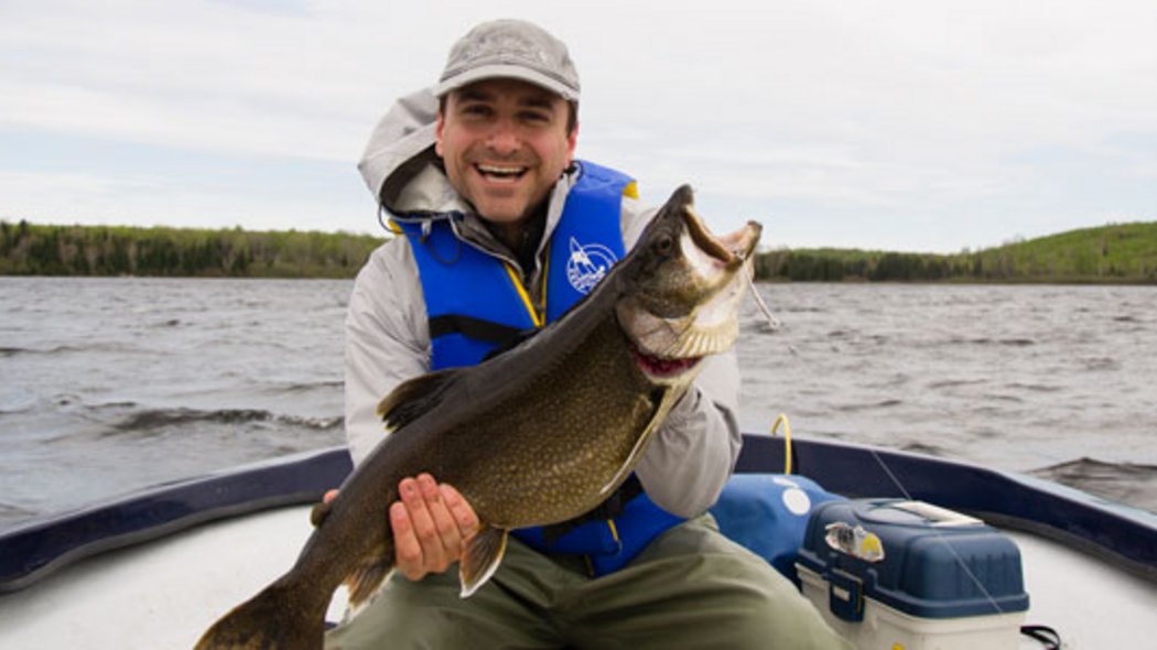 Simon Diotte à la pêche Un homme avec un gros poisson dans les mains.