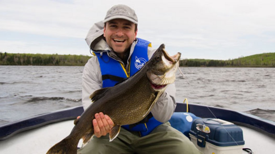 Un homme avec un gros poisson dans les mains.