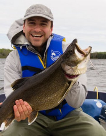 Un homme avec un gros poisson dans les mains.