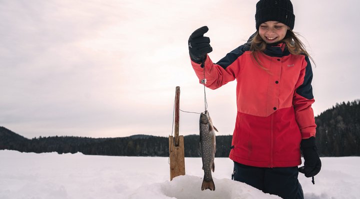 A child catching a fish in winter.