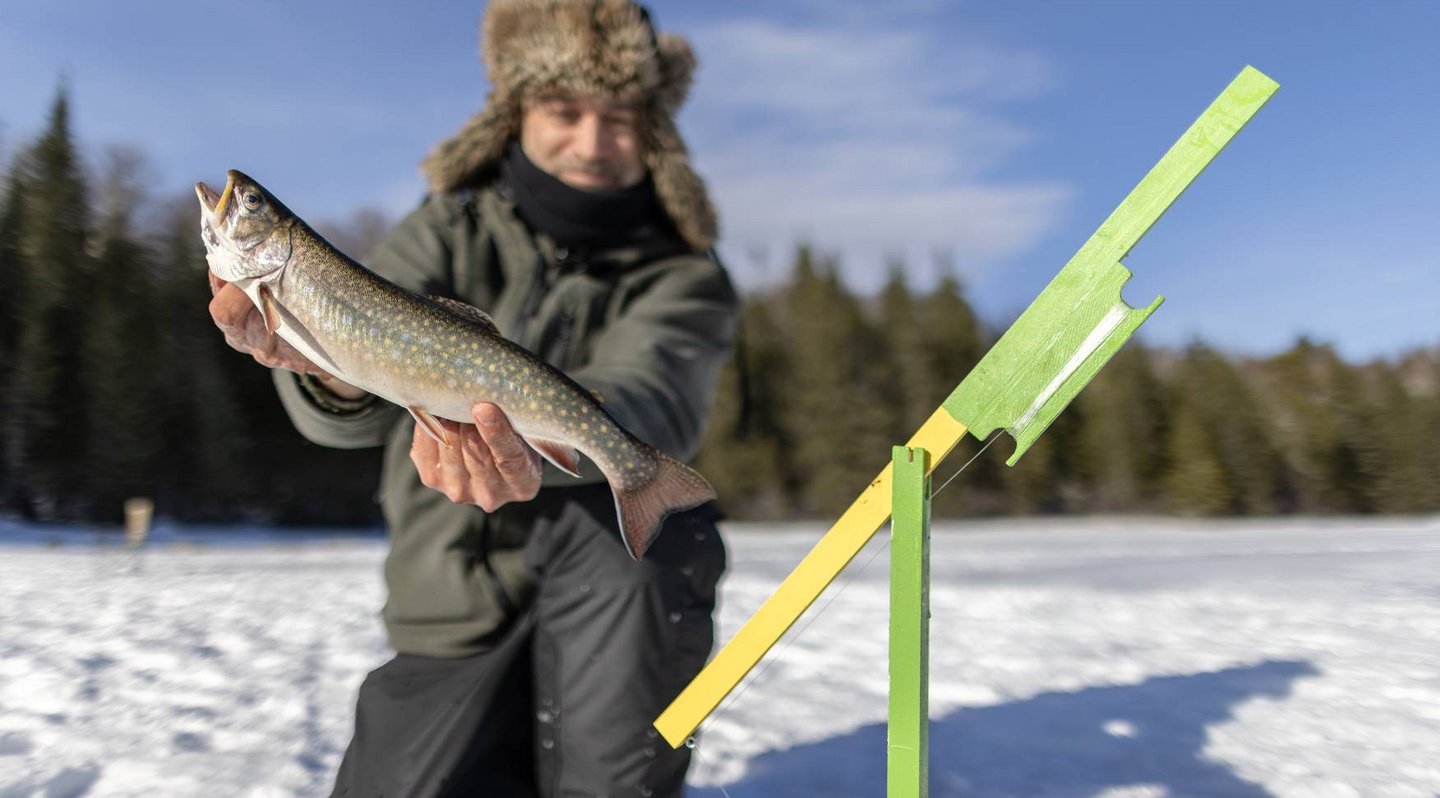 Un homme à la pêche blanche qui montre sa truite