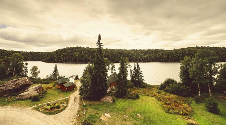 Aerial view of an outfitter with cabin, lake and forest.