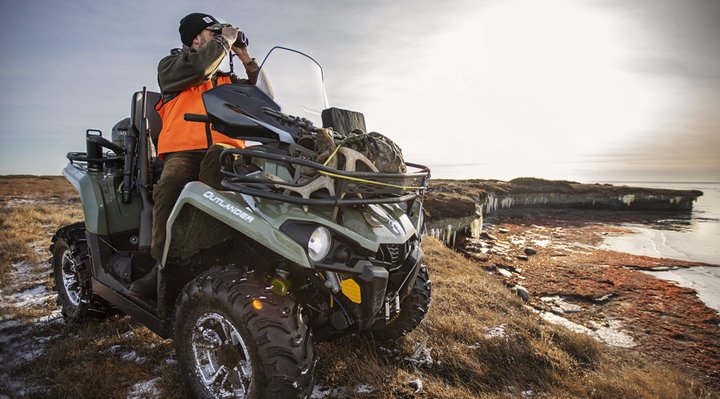 A man on a quad looking through binoculars.