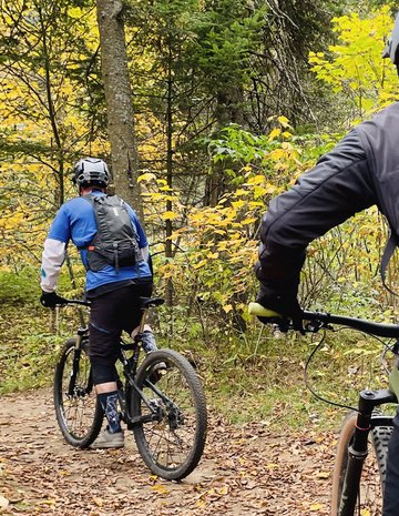 Deux hommes partent en vélo en pourvoirie.