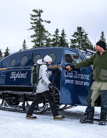 Three adults going for a snowmobile ride.