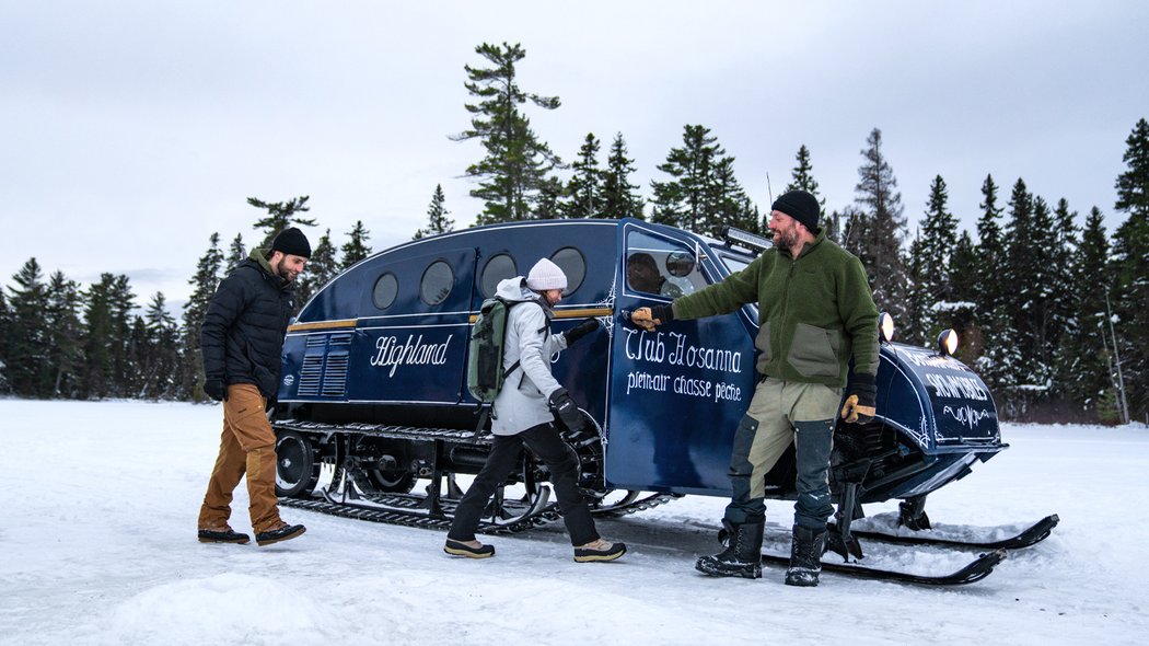 Three adults going for a snowmobile ride.