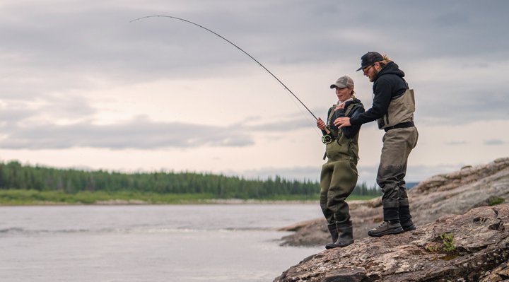 Deux personnes à la pêche sur rives d'une rivière