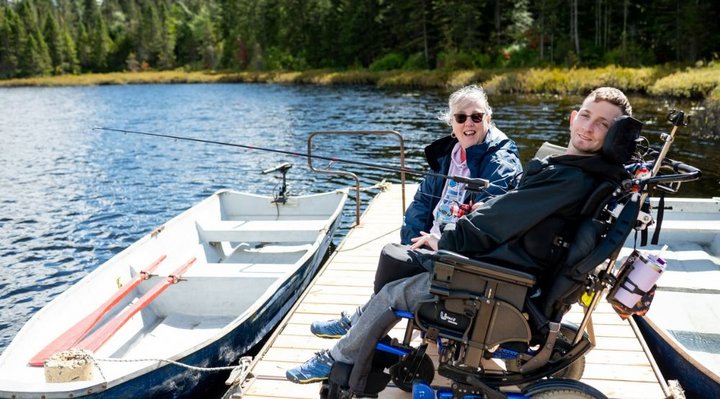 Une personne en situation d'handicap qui pêche sur un quai