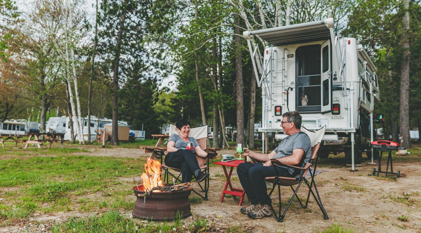 Un couple devant un feu de camp au camping