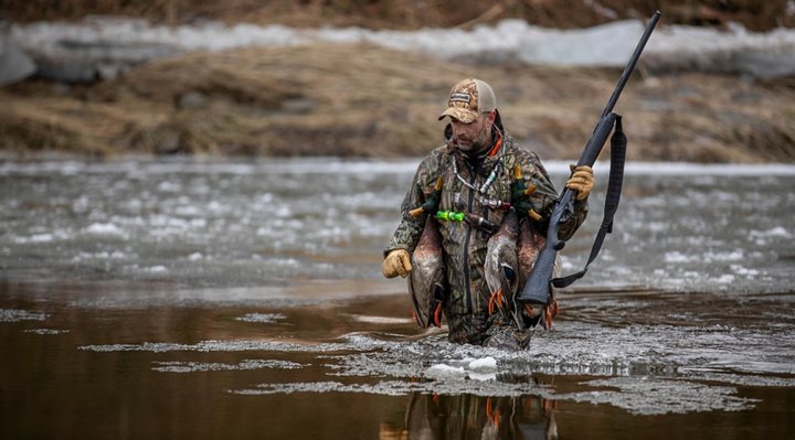 Un chasseur dans l'eau avec ses prises