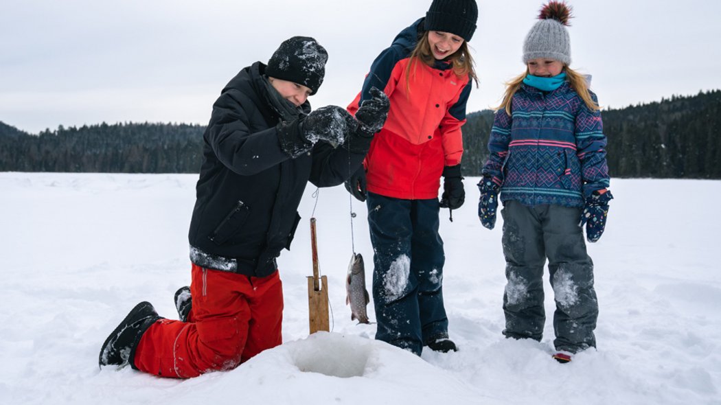 Ice fishing at an outfitters Children fishing in winter.