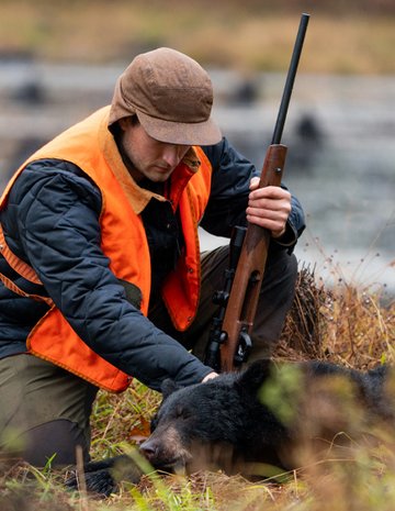 A man hunting a black bear at an outfitter.
