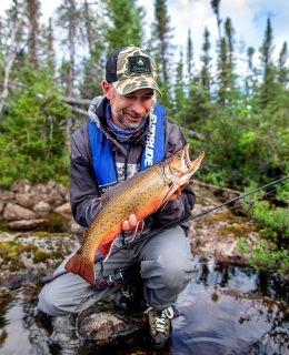 Un pêcheur avec sa truite mouchetée