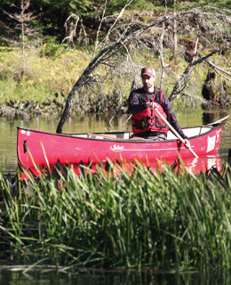 A man paddling a canoe on a river