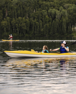 A mother and daughter kayak on lake an outfitter's.