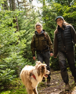 Deux femmes avec un chien en randonnée